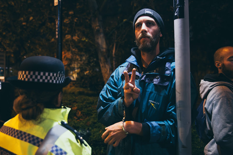 Activist Arrested By Police Does The Peace Sign At Fish Market Protest