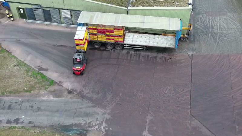 Forklift unloads chicken crates from truck