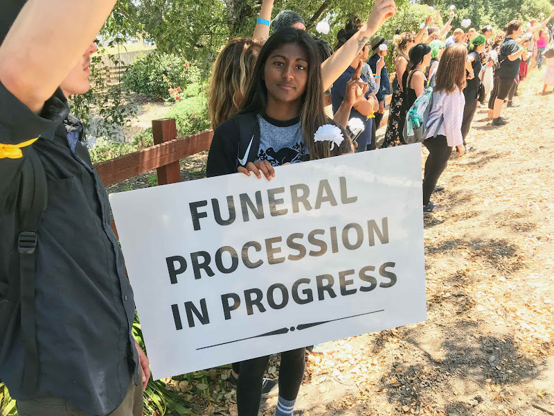 Activist Holding Funeral Procession Sign