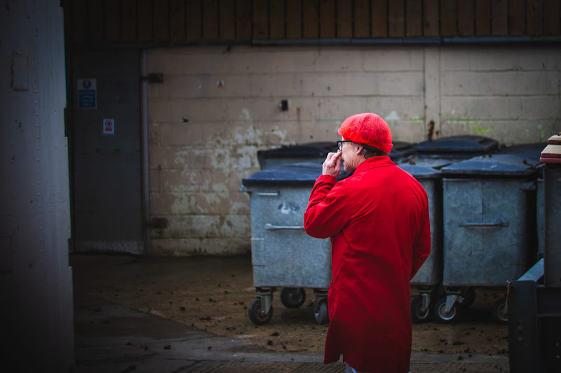 Slaughterhouse worker picking nose